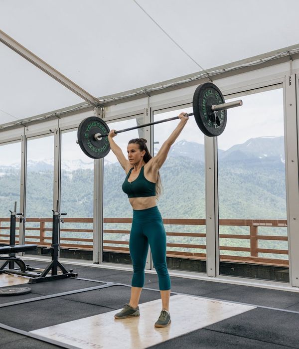 Woman performing a light cardio exercise in a calm, minimalist environment.
